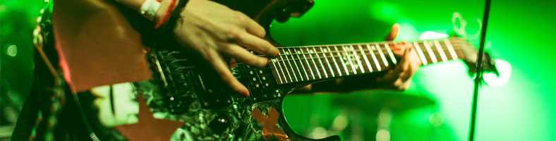 Close-up of someone playing a guitar on stage at a gig