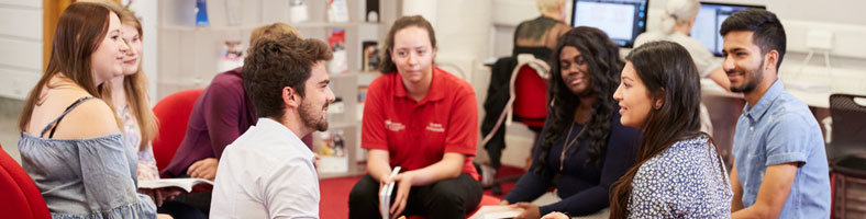 A group of students talking to each other in the library