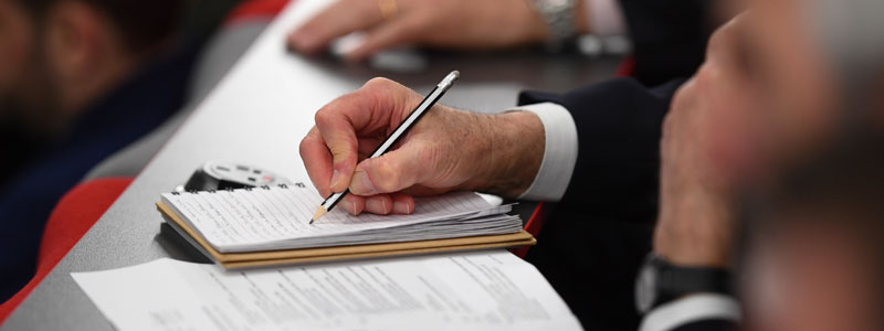 Close up of a person writing on a notepad