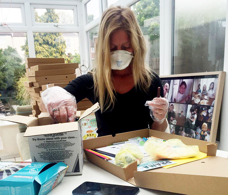 A volunteer filling one of the art to go pizza boxes