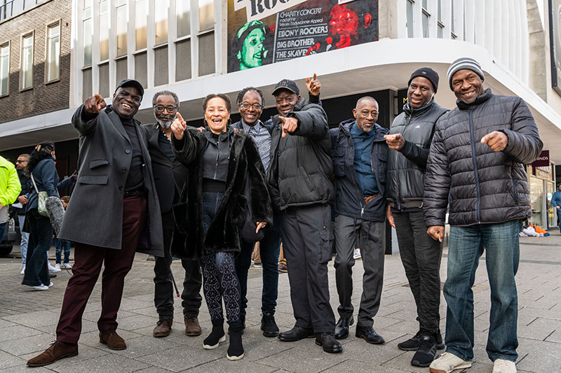 Members of the Ebony Rockers in front of the mural