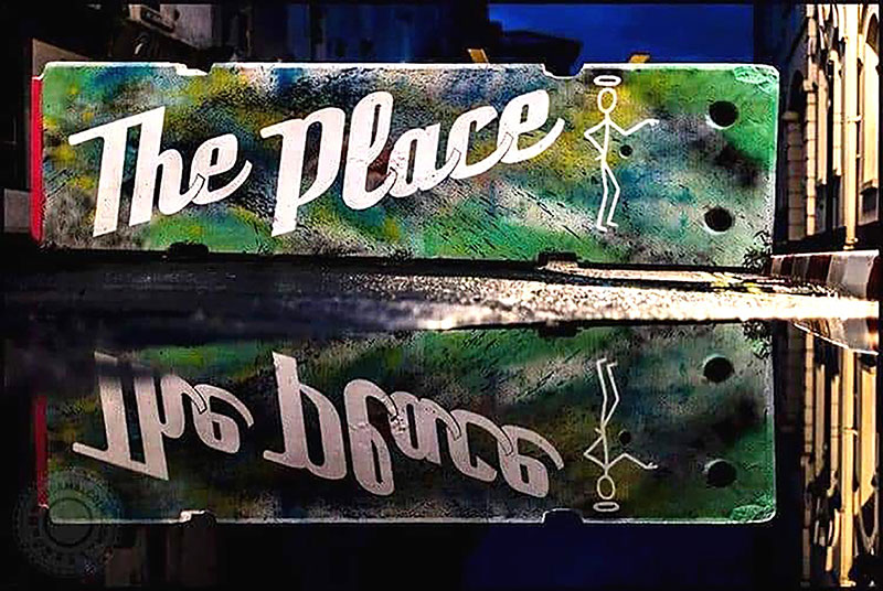 Graffiti saying 'the place' on a road block