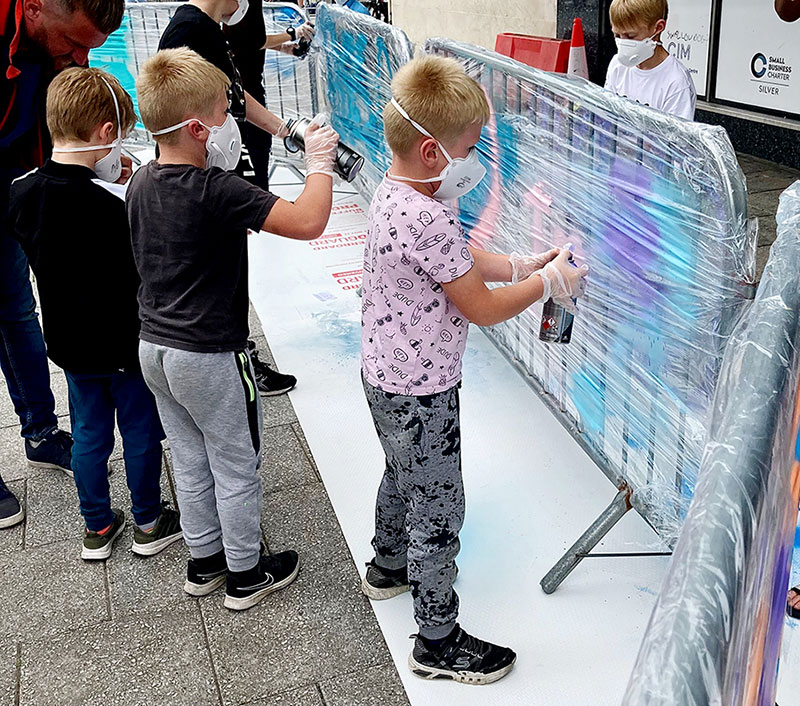 Young children spray painting for an art project