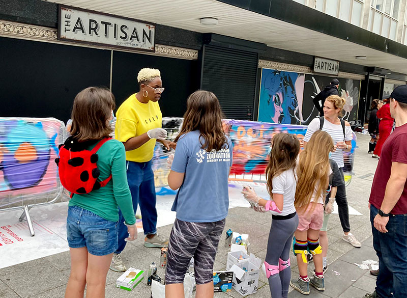 A street jam artist talking to some children