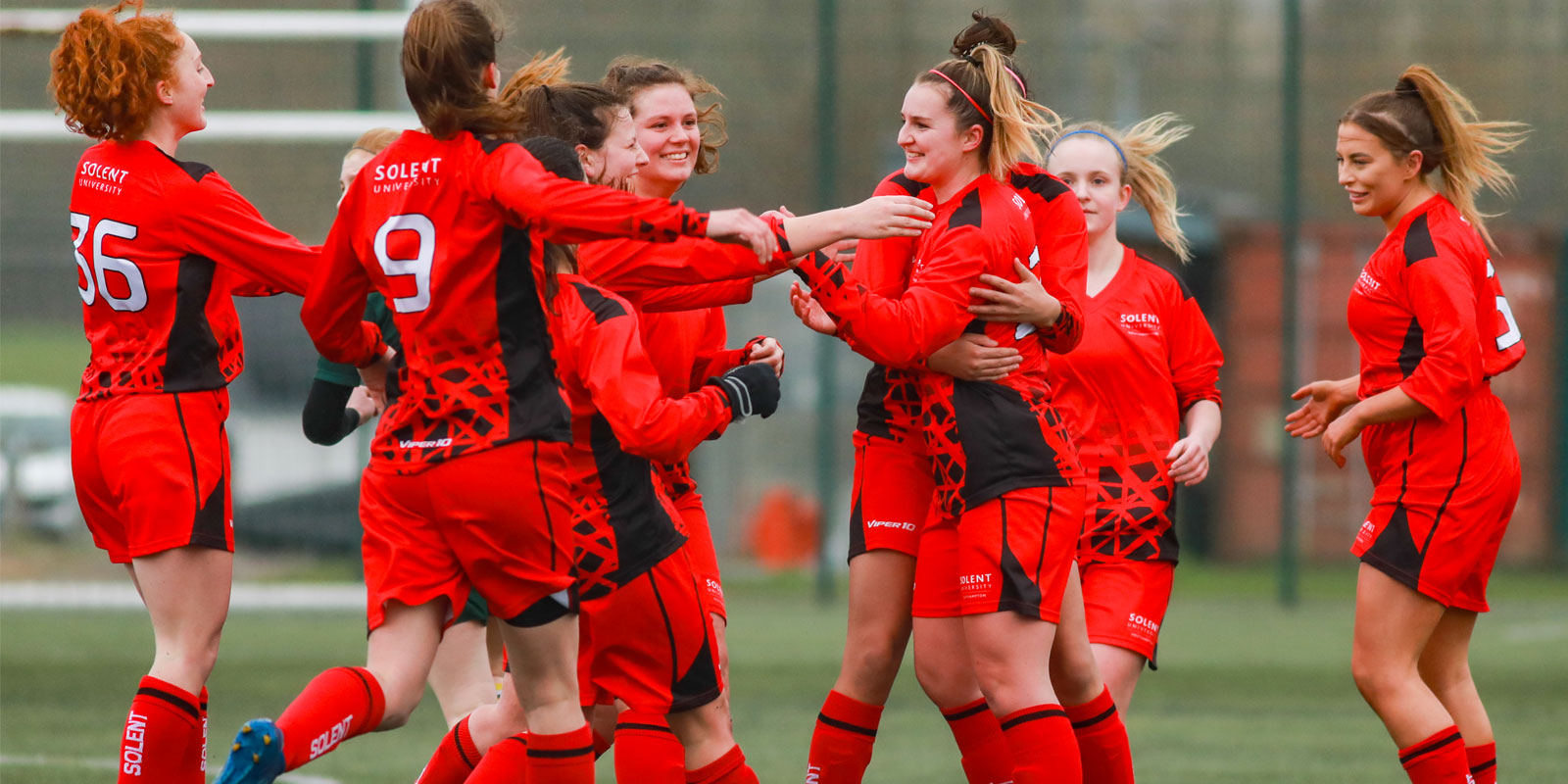 Team Solent women's football players celebrating a goal
