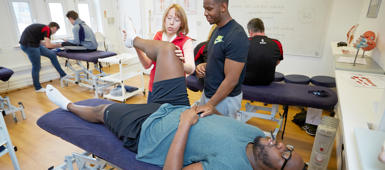 A sport and exercise therapy student in the physiotherapy suite with a tutor